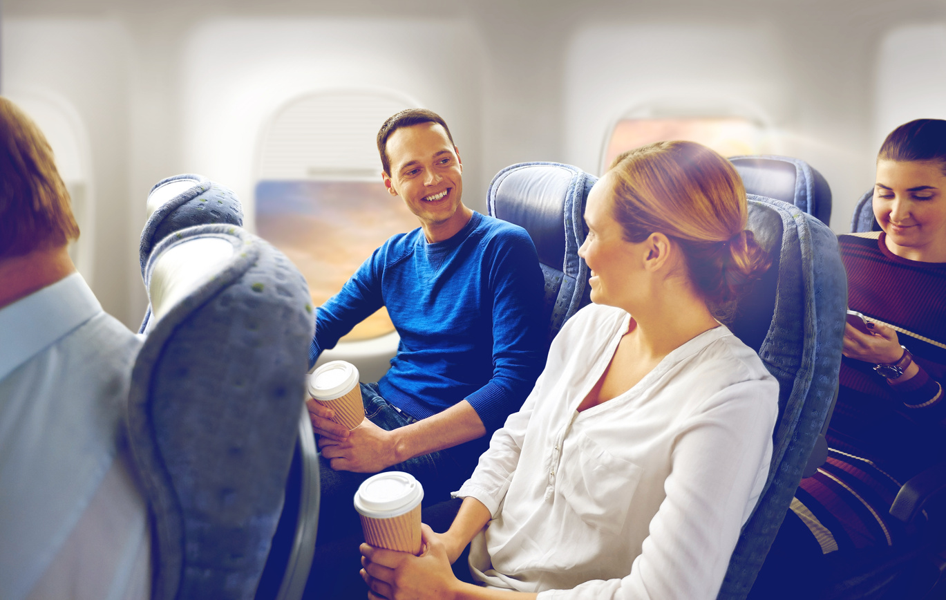 Happy Passengers with Coffee Talking in Plane